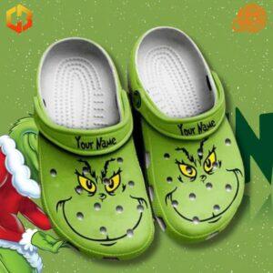 Custom Grinch Crocs Shoes in a snowy, Christmas-themed setting with a glimpse of the Grinch character.