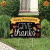 A yard sign with the message 'Give Thanks Happy Thanksgiving