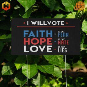 A black yard sign with the words 'I Will Vote Faith, Hope, and Love' in bold, colorful letters.