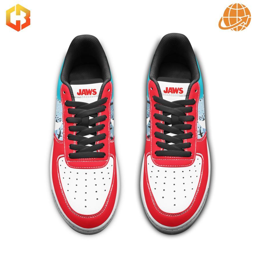 Top-down view of Jaws Nike Air Force Shoes highlighting red toe, white midsection with Nike swoosh, teal heel with shark design, and prominent JAWS branding on tongue.