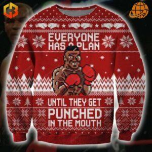 Mike Tyson Christmas Sweater with pixelated boxer image and quote "Everyone has a plan until they get punched in the mouth" on red background with festive patterns.