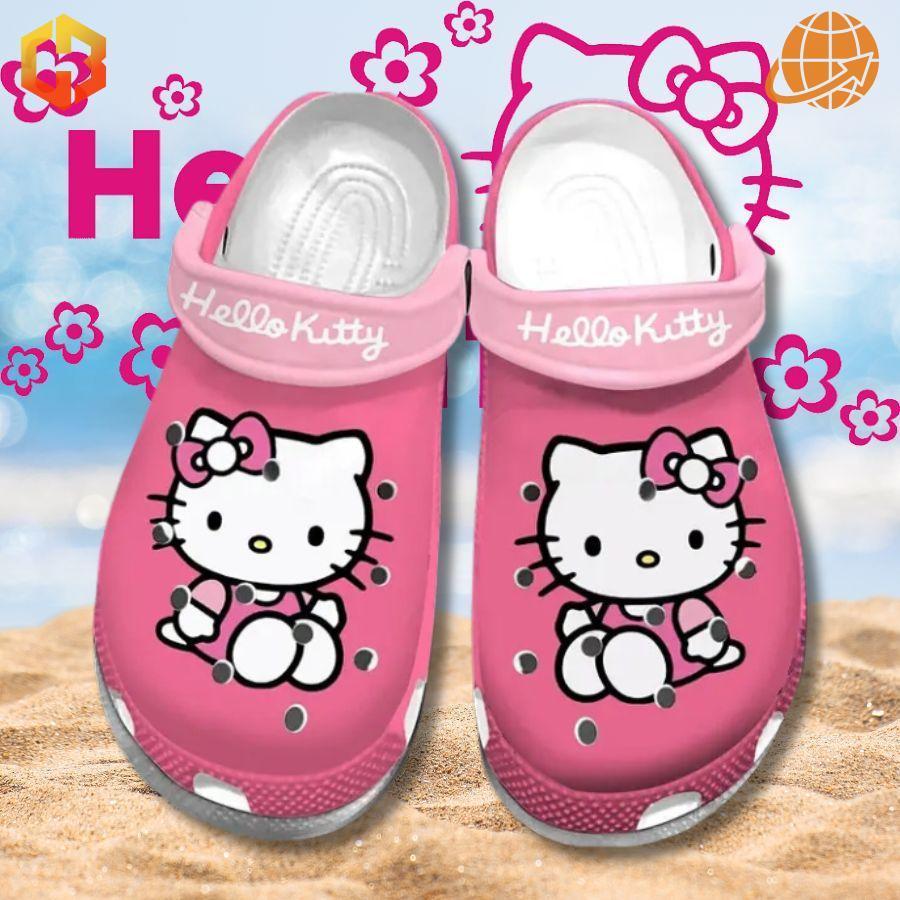 Pink Hello Kitty Crocs Shoes displayed on a sandy beach with a bright and cheerful background.