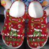 Red Crocs clogs decorated with Grinch characters and Christmas-themed designs.