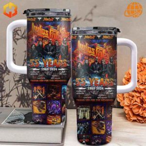 Two sizes of Judas Priest 55th Anniversary Stanley Tumblers displayed with orange flowers and reading material.