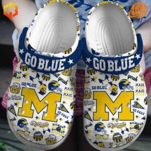 Michigan Football Go Blue Crocs Shoes with maize and blue patterns, Michigan “M” logo, and navy strap with “Go Blue” text.