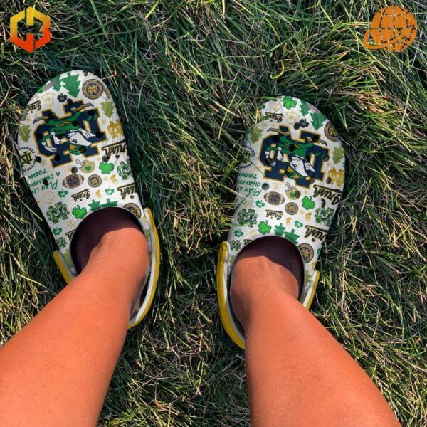 Notre Dame Fighting Irish Crocs Shoes being worn outdoors on grass, showcasing their vibrant design and comfort.