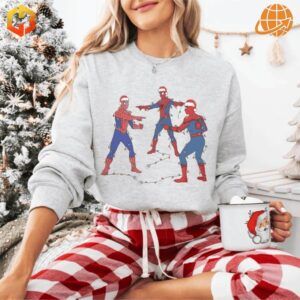 Woman wearing Spider-Man Pointing Meme Sweatshirt in light gray with holiday decor and Christmas tree.