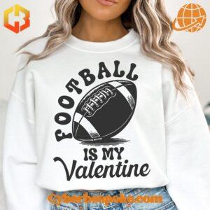 A cozy white sweatshirt with a large, heart-shaped football graphic in the center. The football is red with white laces