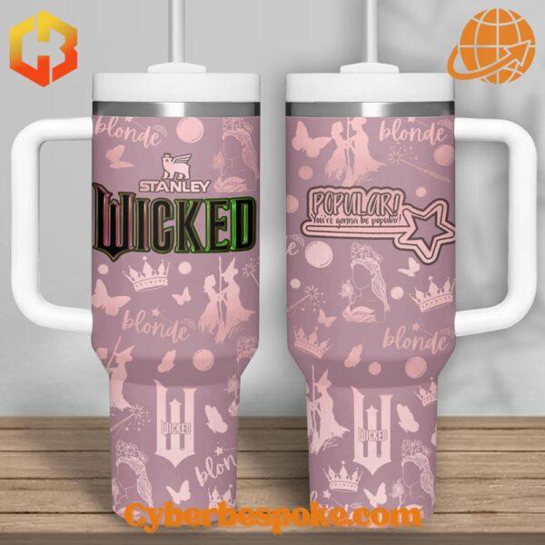 Pink Stanley tumbler with Wicked musical theme design featuring butterflies, crowns, and "Popular" quote.