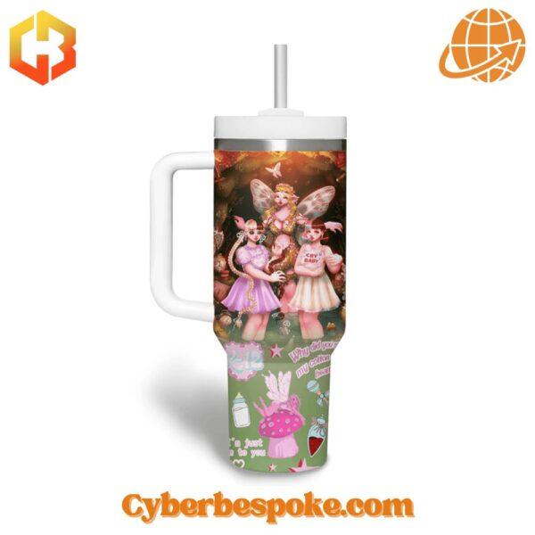 Two 40oz tumblers with handles displaying colorful Melanie Martinez-inspired artwork, including fairy characters and whimsical symbols.